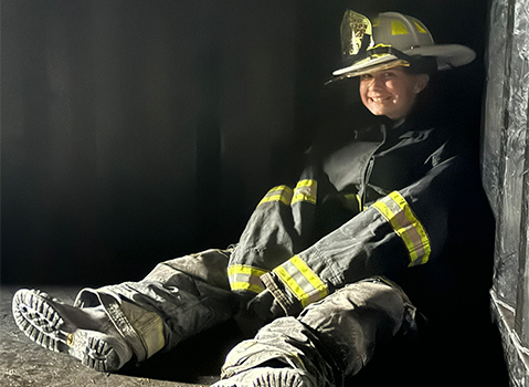Picture of a a young resident dressed in firefighter gear as part of the  Youth Fire Safety Camp